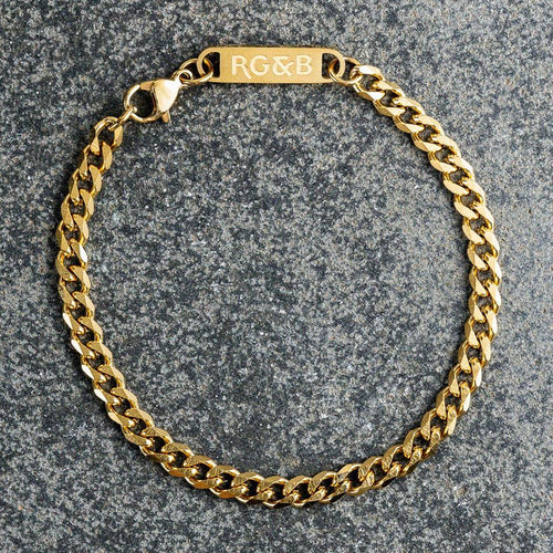 Our Gold Cuban Chain Bracelet features our premium gold cuban chain and signature polished gold plate, engraved with RG&B.