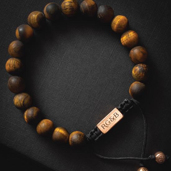 Tiger's Eye Bead Bracelet - Our Tiger’s Eye Bead Bracelet Features Natural Stones, Waxed Cord and Brushed Rose Gold Steel Hardware. A Beautiful Addition to any Collection.